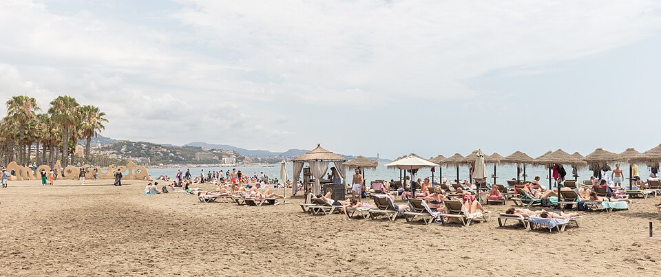 Solbadare som fyller La Malagueta-stranden