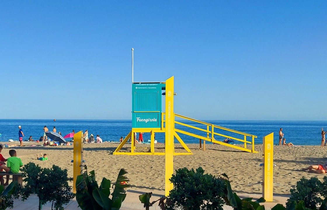 Familier på stranden i Fuengirola ved det farverige livredningstårn