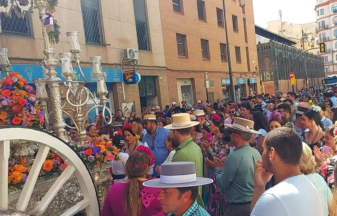 Flamencokjoler og bredskyggede hatte bag sølvcarretaen under romería del Rocío i Málaga